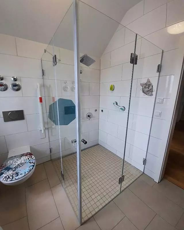 Eckdusche mit Falttüren aus Glas MF2S barrierefrei auf beigen Mosaikfliesen