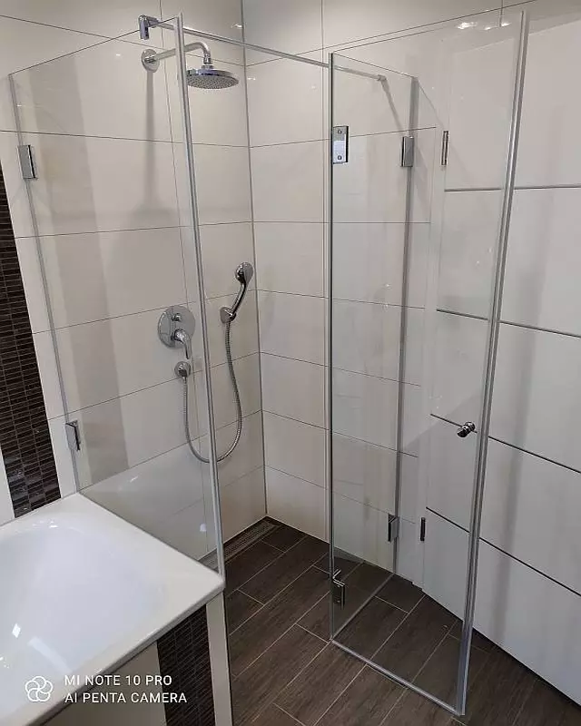 Dusche neben Badewanne A2K aus Glas mit Duschrinne auf braunen Bodenfliesen
