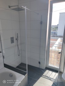 Dusche neben Badewanne A1K mit voll öffnender Tür aus Glas ebenerdig auf grauen Bodenfliesen